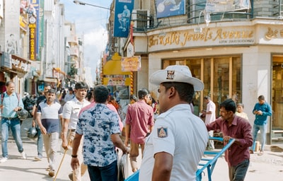 白天站在街上的一个穿着白色t恤和棕色帽子的男人